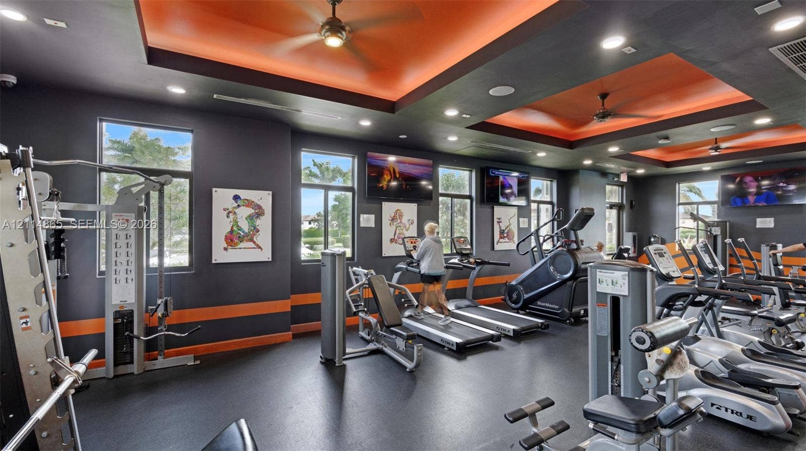 3754 NE 2nd Street, Homestead, FL 33033 Fitness center featuring recessed tray ceilings with accent lighting, multiple ceiling fans, recessed lighting, and large windows