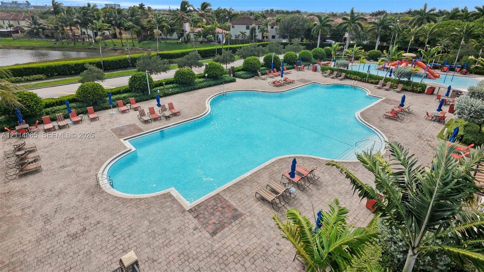3754 NE 2nd Street, Homestead, FL 33033 Large swimming pool featuring a brick-paved deck, secondary water play area, and perimeter landscaping