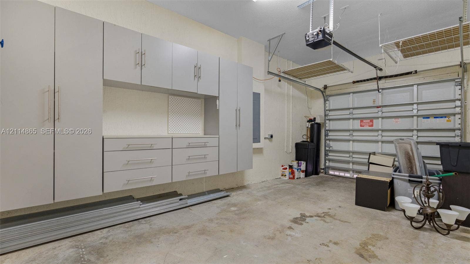 3754 NE 2nd Street, Homestead, FL 33033 Garage featuring extensive wall-mounted cabinetry, integrated drawer storage, and overhead ceiling-mounted shelving