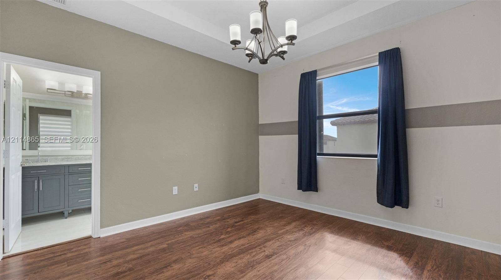 3754 NE 2nd Street, Homestead, FL 33033 Room featuring wood-finish flooring, a tray ceiling, and a multi-arm chandelier