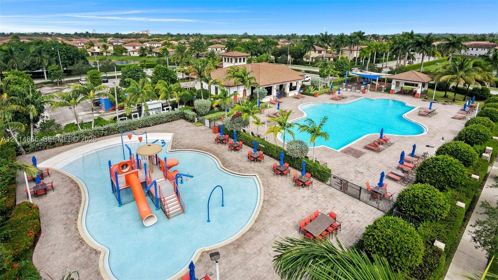3754 NE 2nd Street, Homestead, FL 33033 Community recreation area featuring a large swimming pool, splash pad with water play structures, paved deck, and a clubhouse