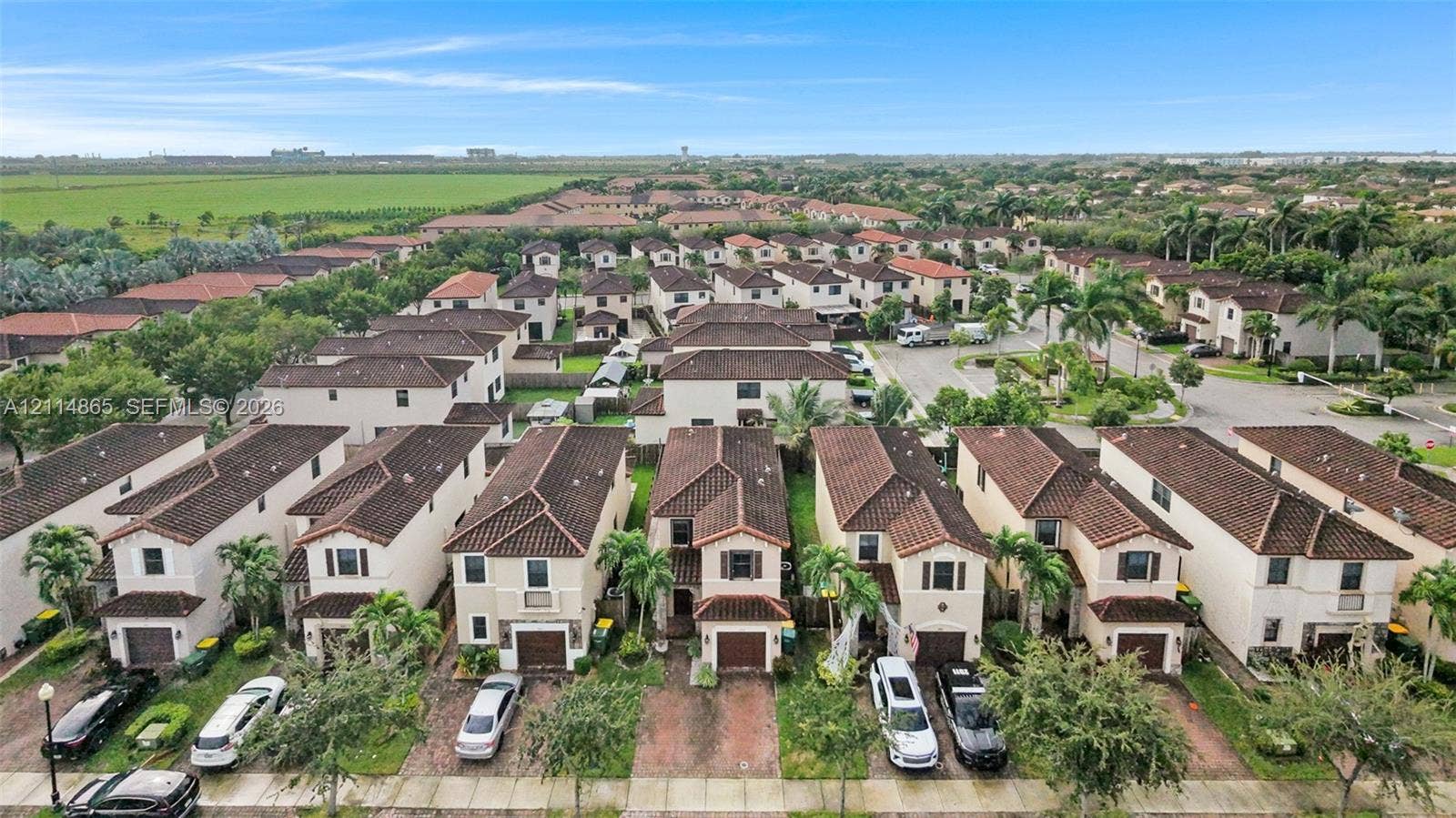 3754 NE 2nd Street, Homestead, FL 33033 Two-story residential structures featuring tile roofs, stucco exteriors, and attached single-car garages