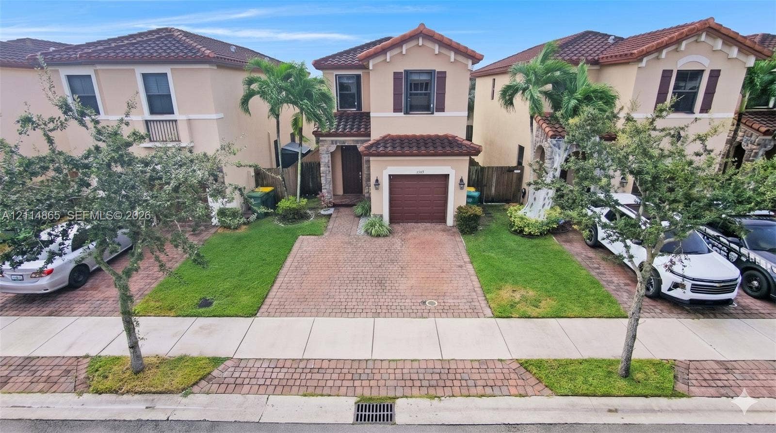 3754 NE 2nd Street, Homestead, FL 33033 Stucco exterior featuring a tiled roof, stone veneer accents, integrated garage, and paved driveway