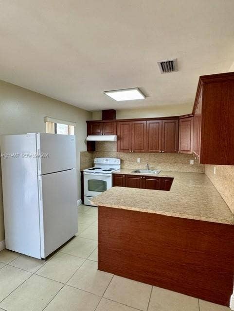 1663 W 41st Street, #1663, Hialeah, Hialeah, FL 33012 Kitchen featuring wood-finish cabinetry, neutral solid-surface countertops, tile flooring, and integrated white appliances