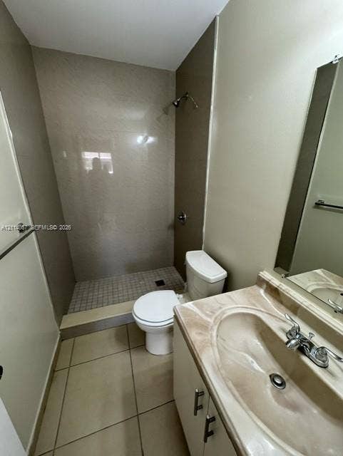 1663 W 41st Street, #1663, Hialeah, Hialeah, FL 33012 Bathroom featuring a vanity with a molded countertop and integrated sink, walk-in shower with tile surround, mosaic tile shower floor, and large-format floor tiling