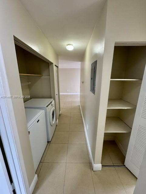 1663 W 41st Street, #1663, Hialeah, Hialeah, FL 33012 Utility space featuring large-format neutral tile flooring, built-in shelving, and a dedicated laundry area with overhead storage