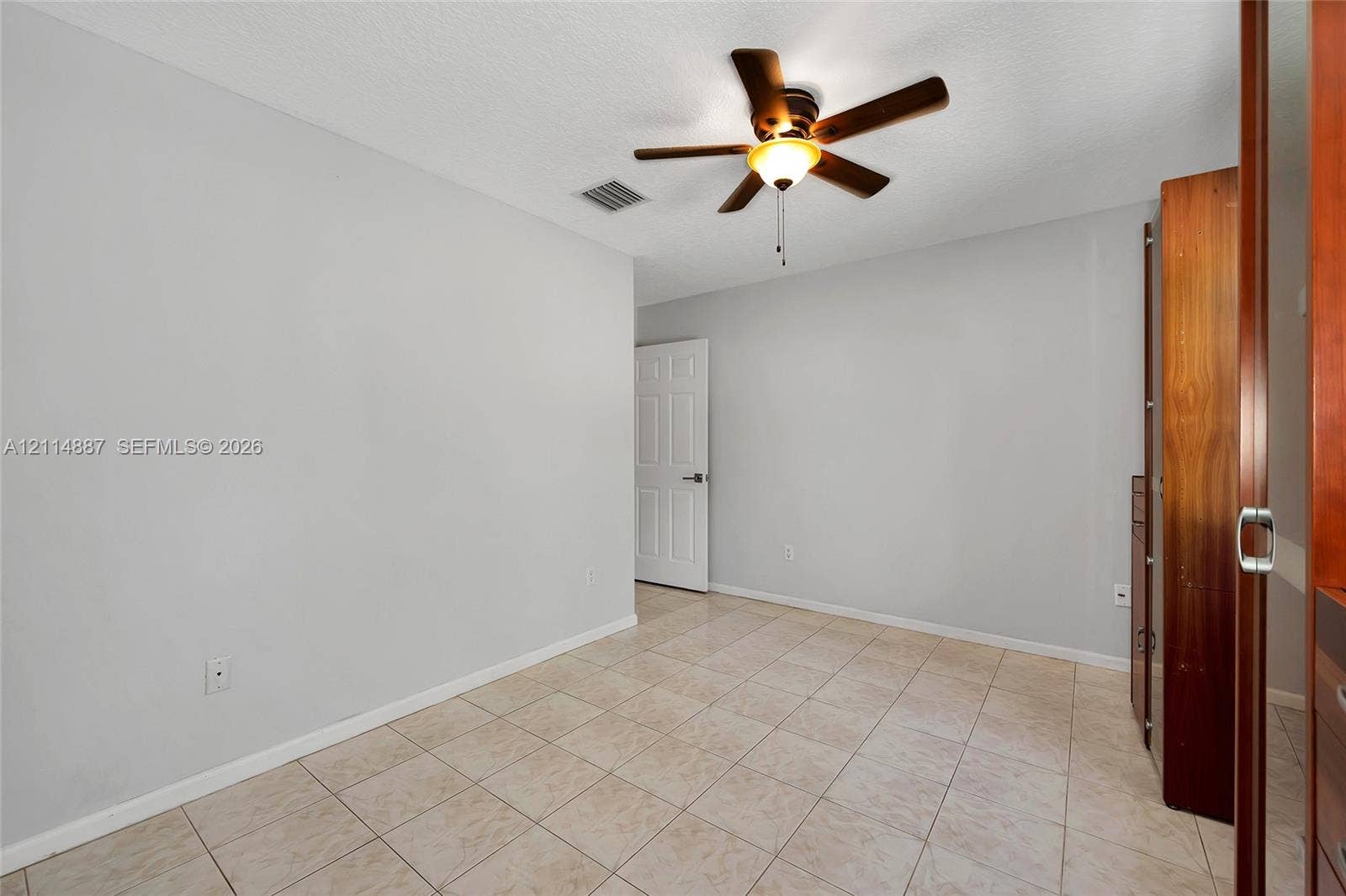 5722 Aspen Ridge Circle, Delray Beach, FL 33484 Neutral wall tones, ceramic tile flooring, ceiling fan with light fixture, and built-in closet cabinetry