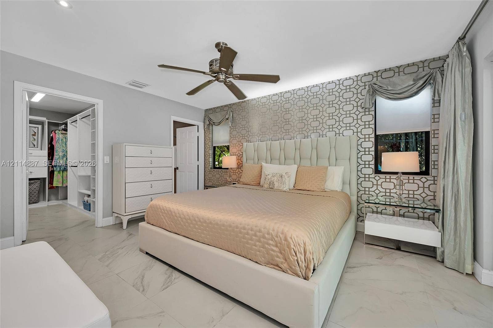 5722 Aspen Ridge Circle, Delray Beach, FL 33484 Large-format tile flooring, patterned wallpaper accent wall, integrated ceiling fan, recessed lighting, and walk-in closet with built-in shelving