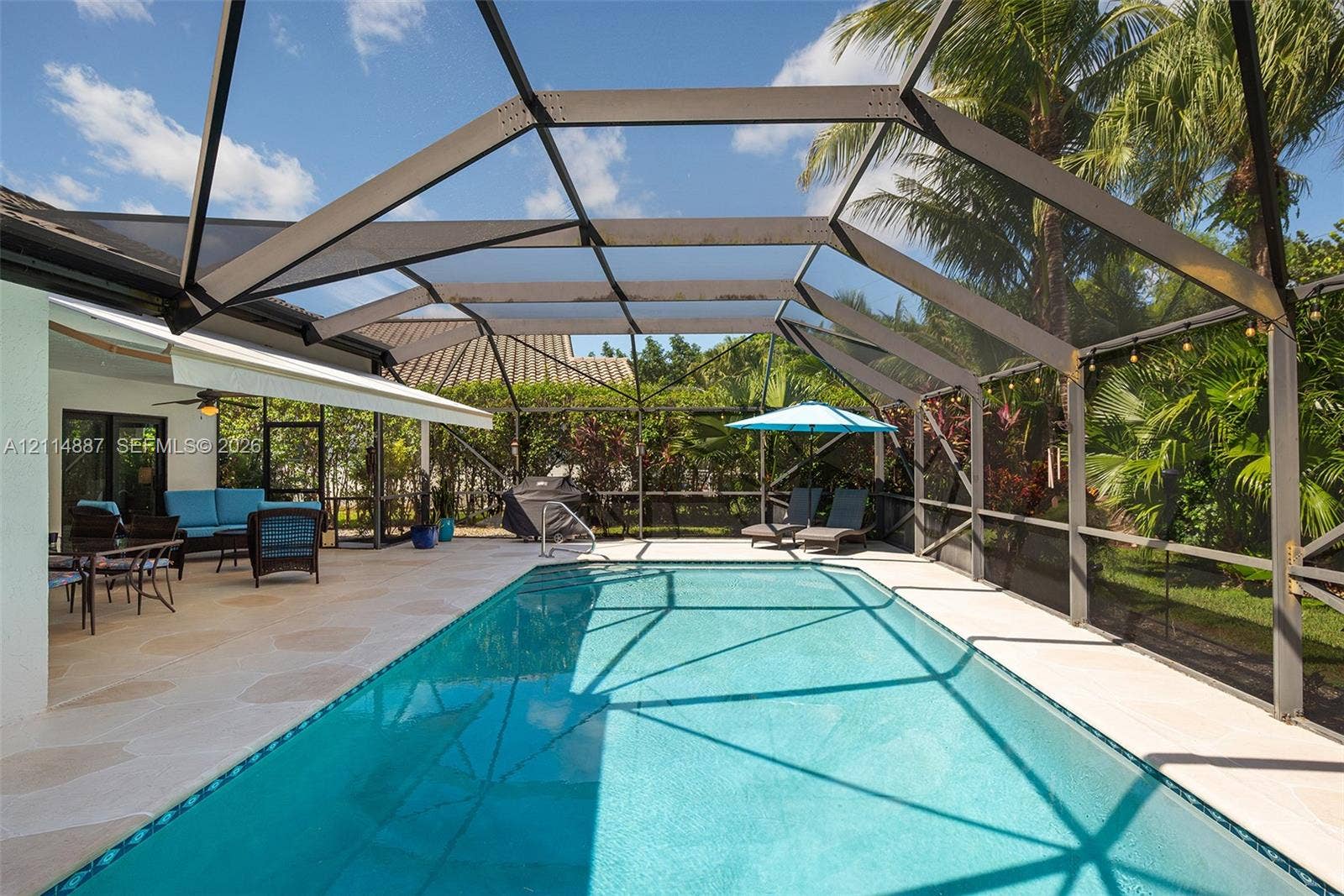 5722 Aspen Ridge Circle, Delray Beach, FL 33484 Screened-in patio enclosure featuring a swimming pool, concrete deck, and perimeter landscaping