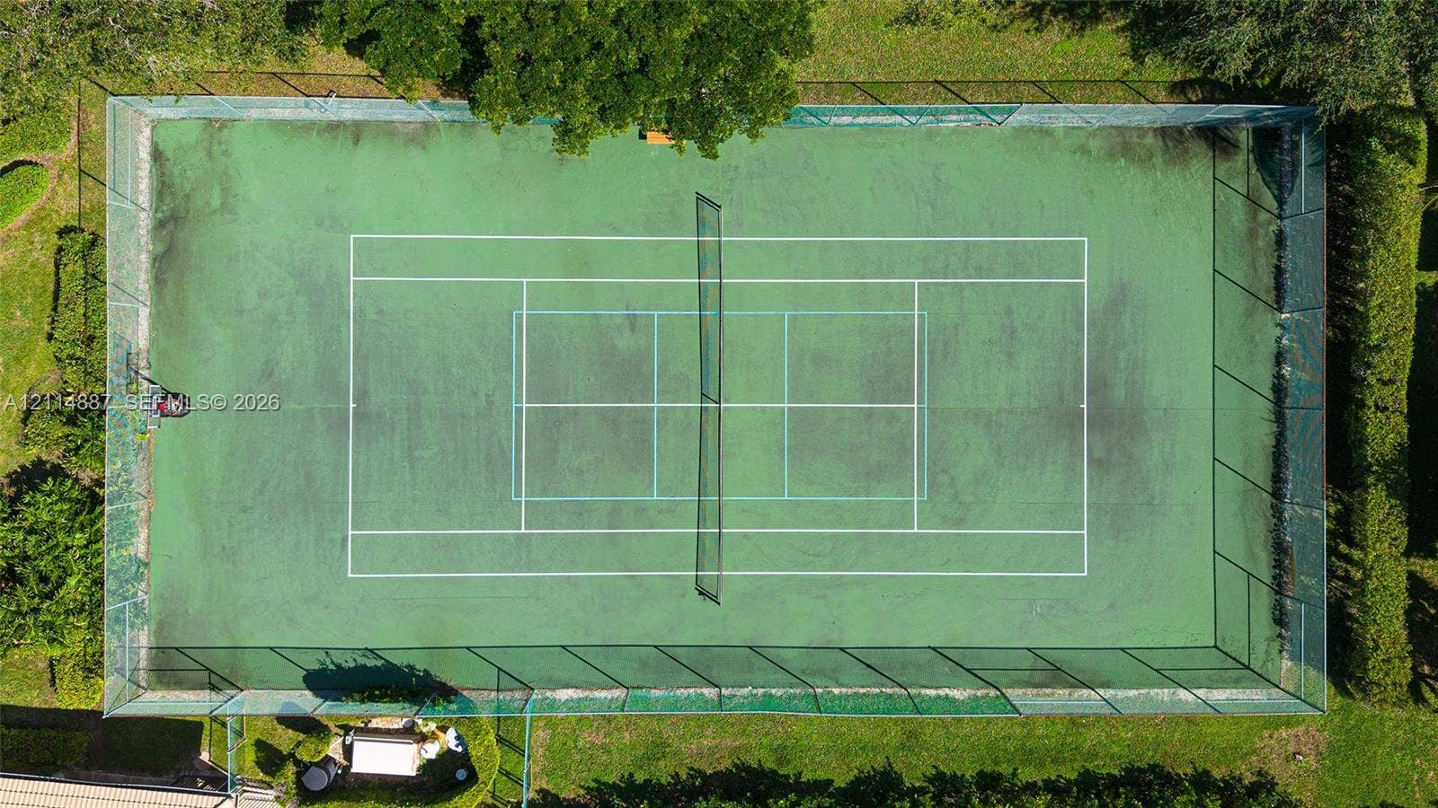 5722 Aspen Ridge Circle, Delray Beach, FL 33484 Private tennis court featuring a fenced perimeter and surrounding mature landscaping