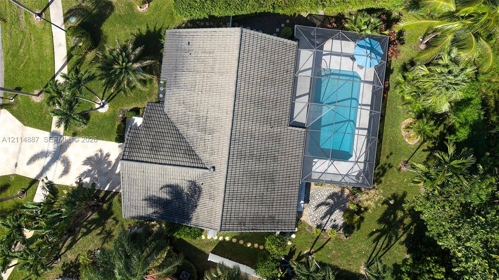 5722 Aspen Ridge Circle, Delray Beach, FL 33484 Aerial view featuring a screened-in swimming pool, shingle roof, paved walkway, and landscaping