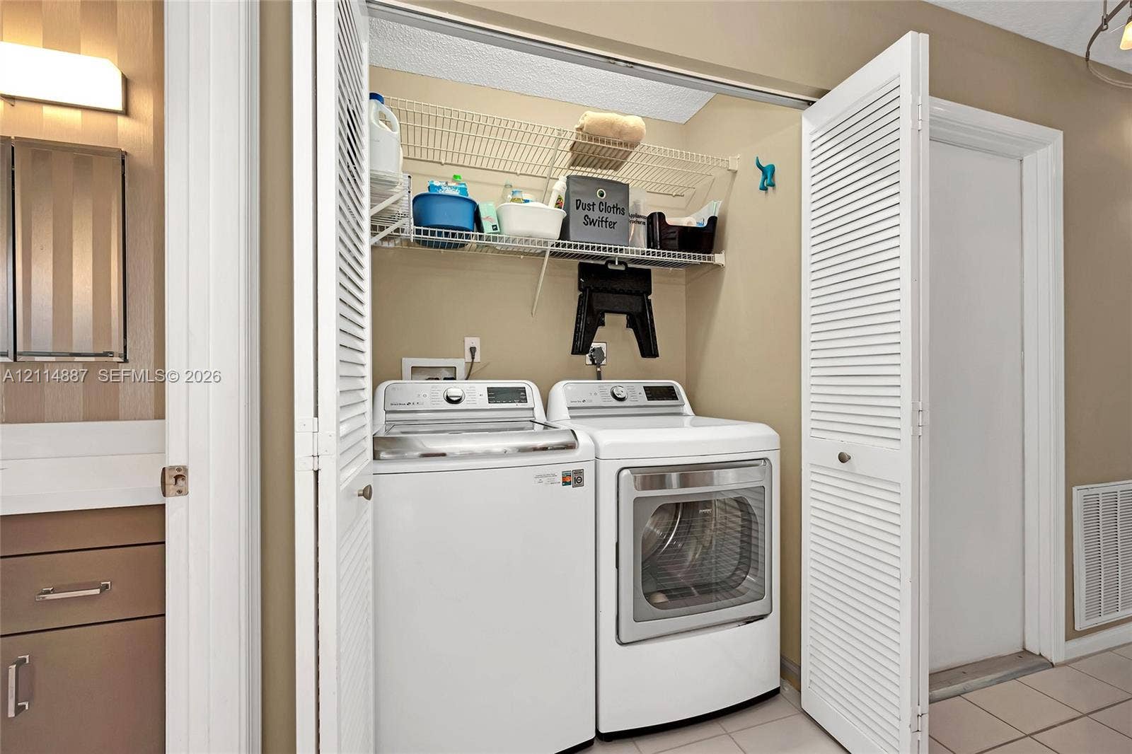 5722 Aspen Ridge Circle, Delray Beach, FL 33484 Laundry alcove featuring white louvered bifold doors and built-in wire shelving