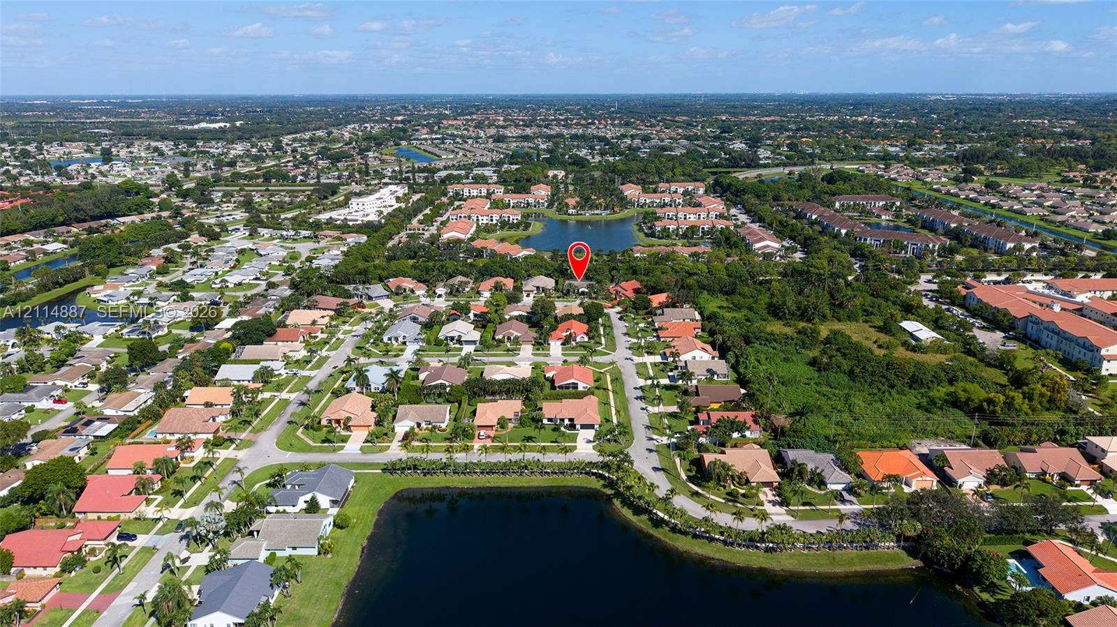 5722 Aspen Ridge Circle, Delray Beach, FL 33484 Aerial perspective of a residential subdivision featuring paved streets, tile-roofed structures, and bodies of water