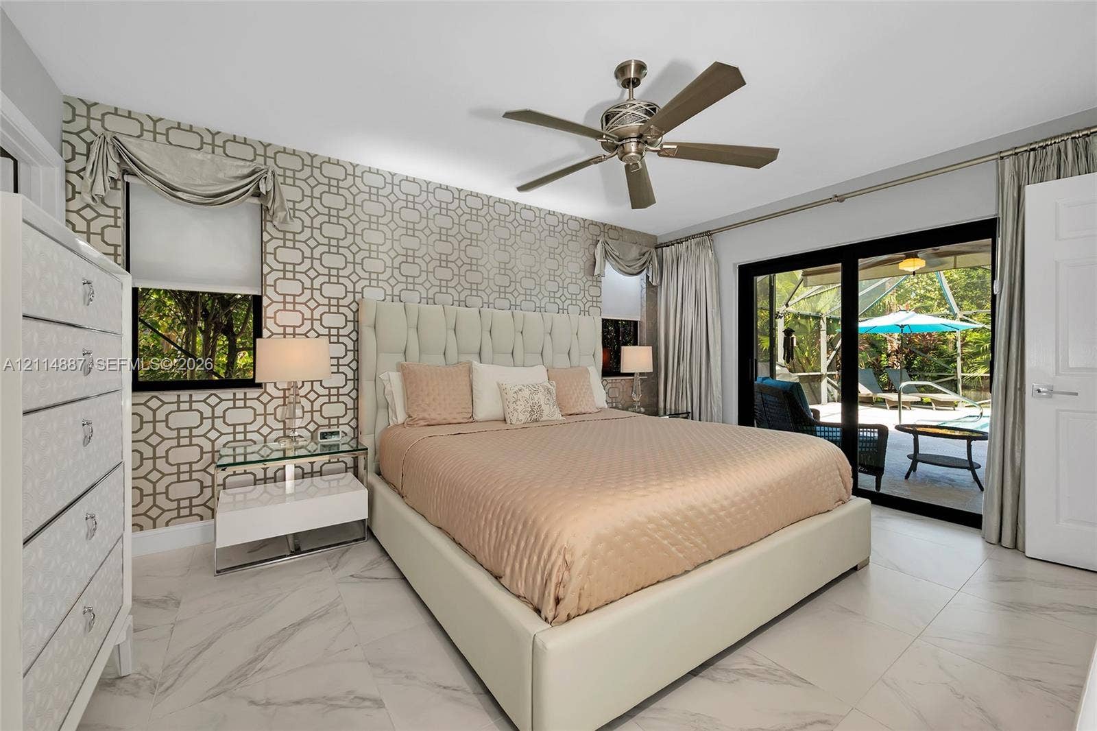 5722 Aspen Ridge Circle, Delray Beach, FL 33484 Room featuring tile flooring with stone-pattern veining, geometric-patterned accent wallpaper, and a metal-finish ceiling fan