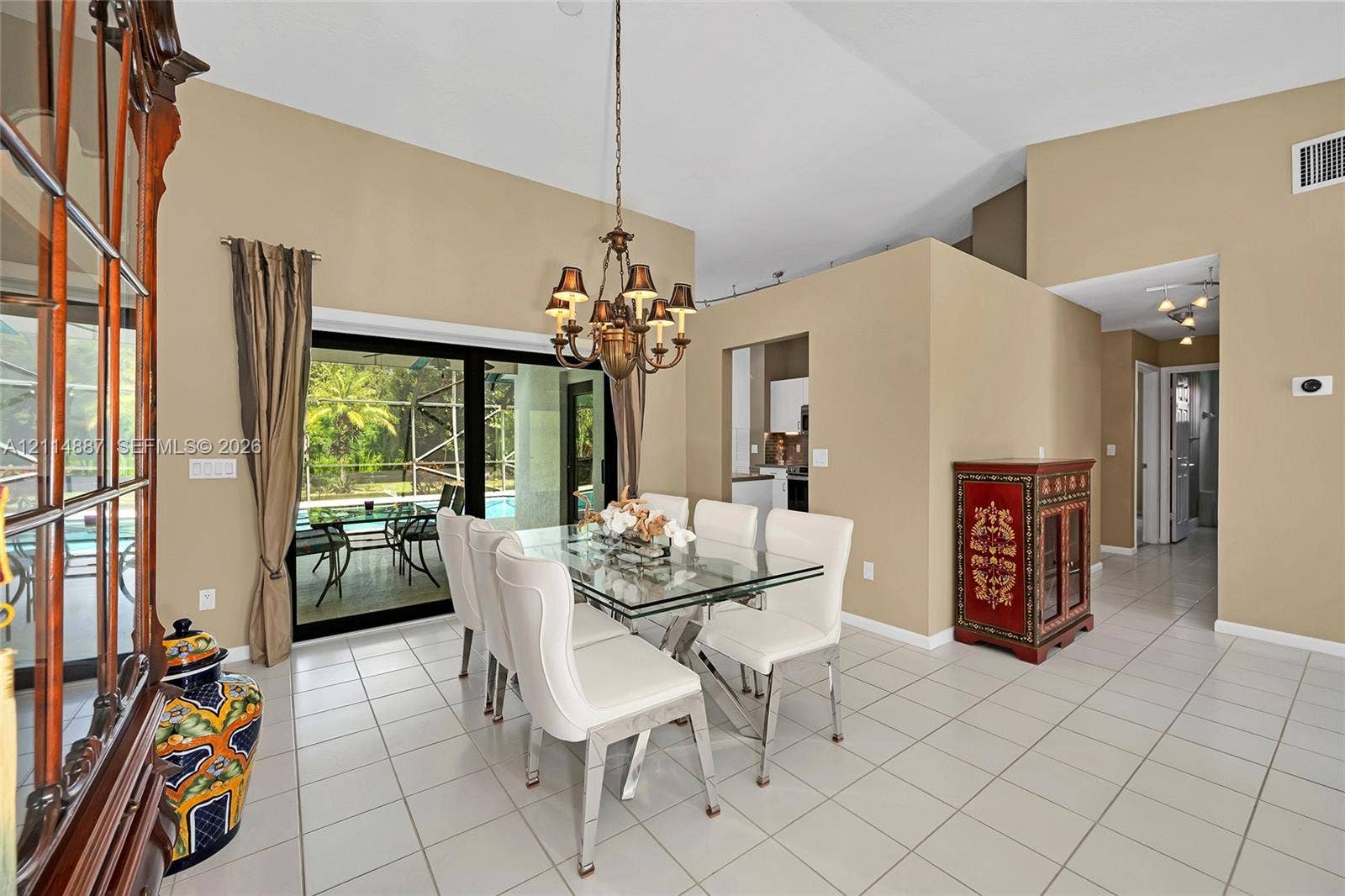 5722 Aspen Ridge Circle, Delray Beach, FL 33484 Dining area featuring vaulted ceilings, oversized ceramic tile flooring, a multi-arm chandelier, and sliding glass doors