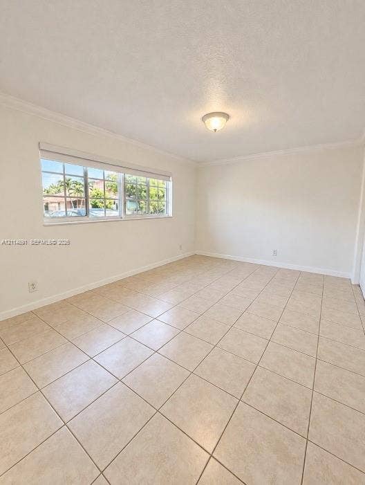 Neutral interior space featuring large-format ceramic tile flooring, multi-pane windows, crown molding, and a central dome-style light fixture