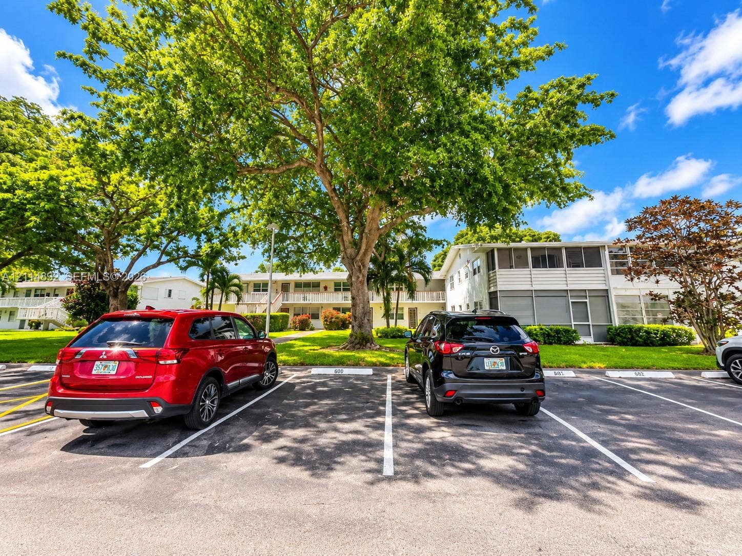 582 Durham U, #582, Deerfield Beach, FL 33442 Asphalt surface parking lot featuring designated stall markings and mature shade trees
