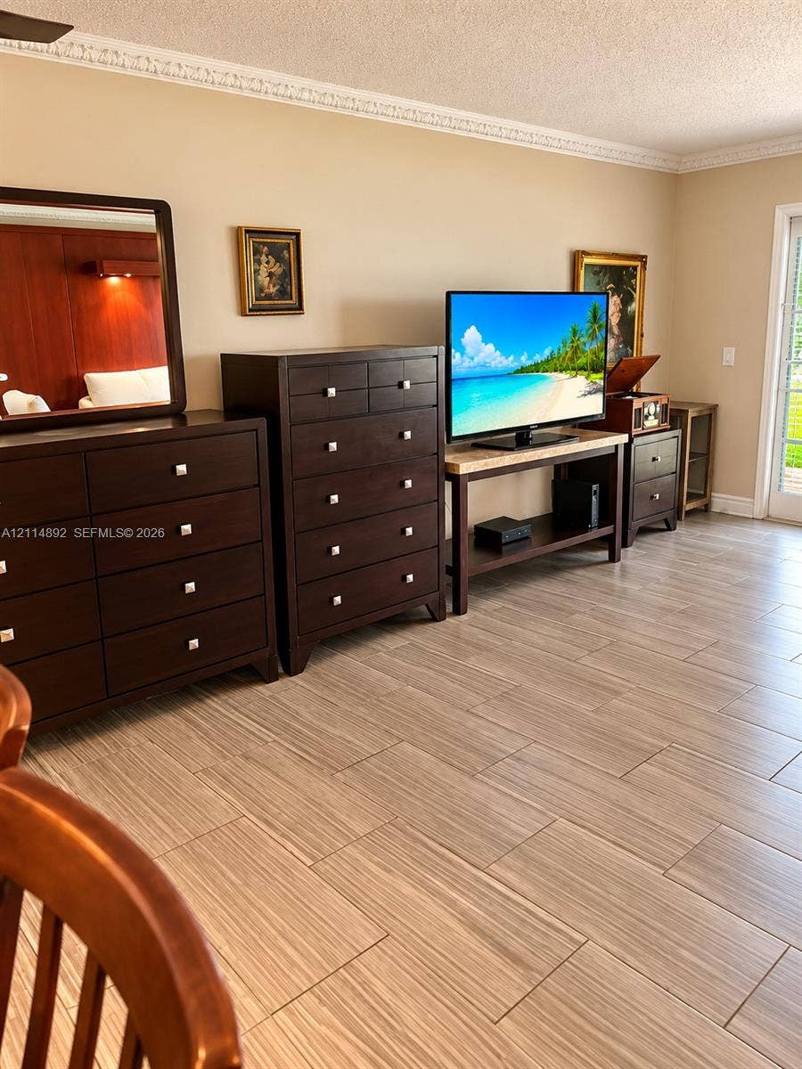 582 Durham U, #582, Deerfield Beach, FL 33442 Neutral wall tones accented by crown molding, wood-finish tile flooring, and a glass-paneled door