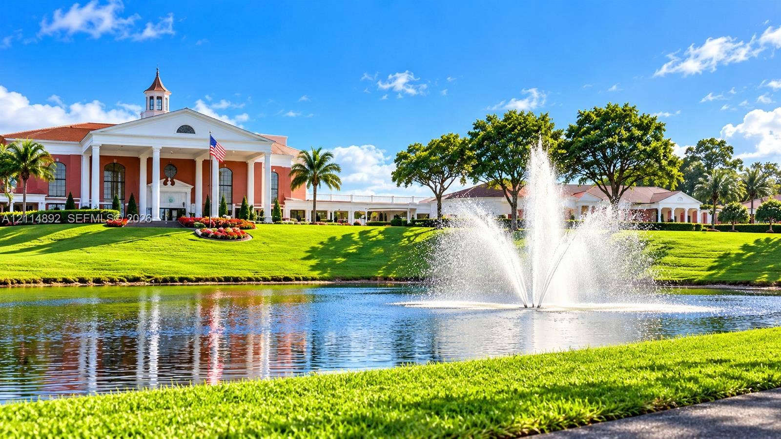 582 Durham U, #582, Deerfield Beach, FL 33442 Neoclassical architecture featuring a prominent portico with grand columns, a centralized cupola, manicured landscaping, and a large central water fountain on a pond