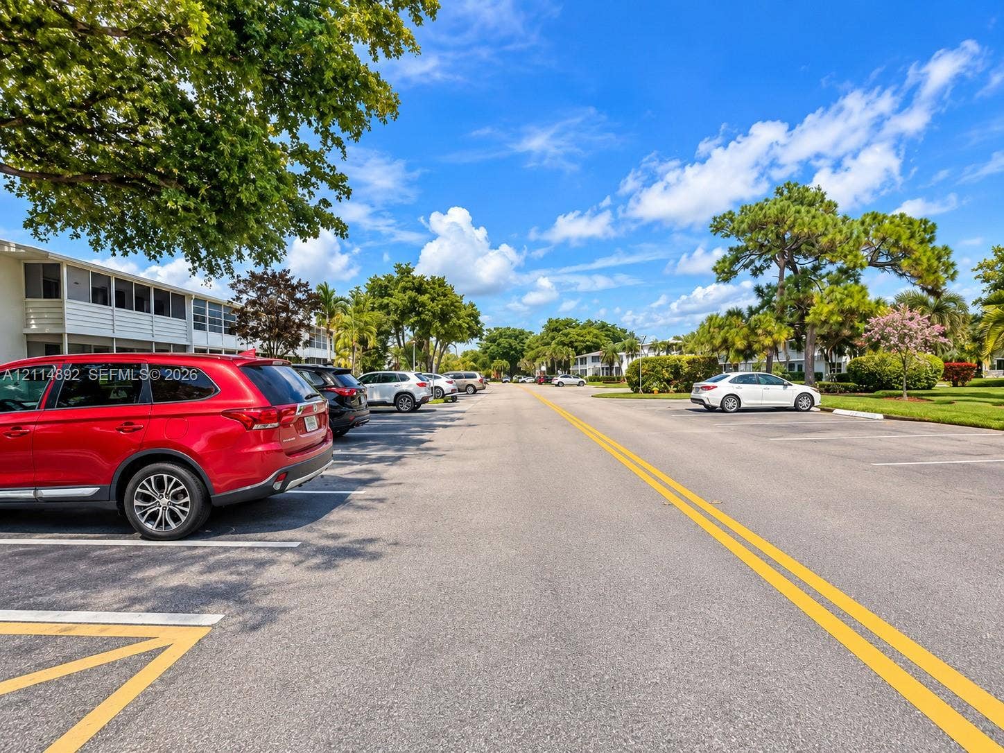582 Durham U, #582, Deerfield Beach, FL 33442 Paved surface parking area featuring marked spaces and mature shade trees