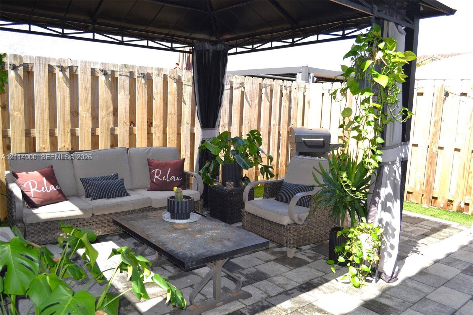 25048 SW 113th Place, Homestead, FL 33032 Outdoor gazebo featuring a metal frame, concrete paver patio, and wood-slat privacy fencing