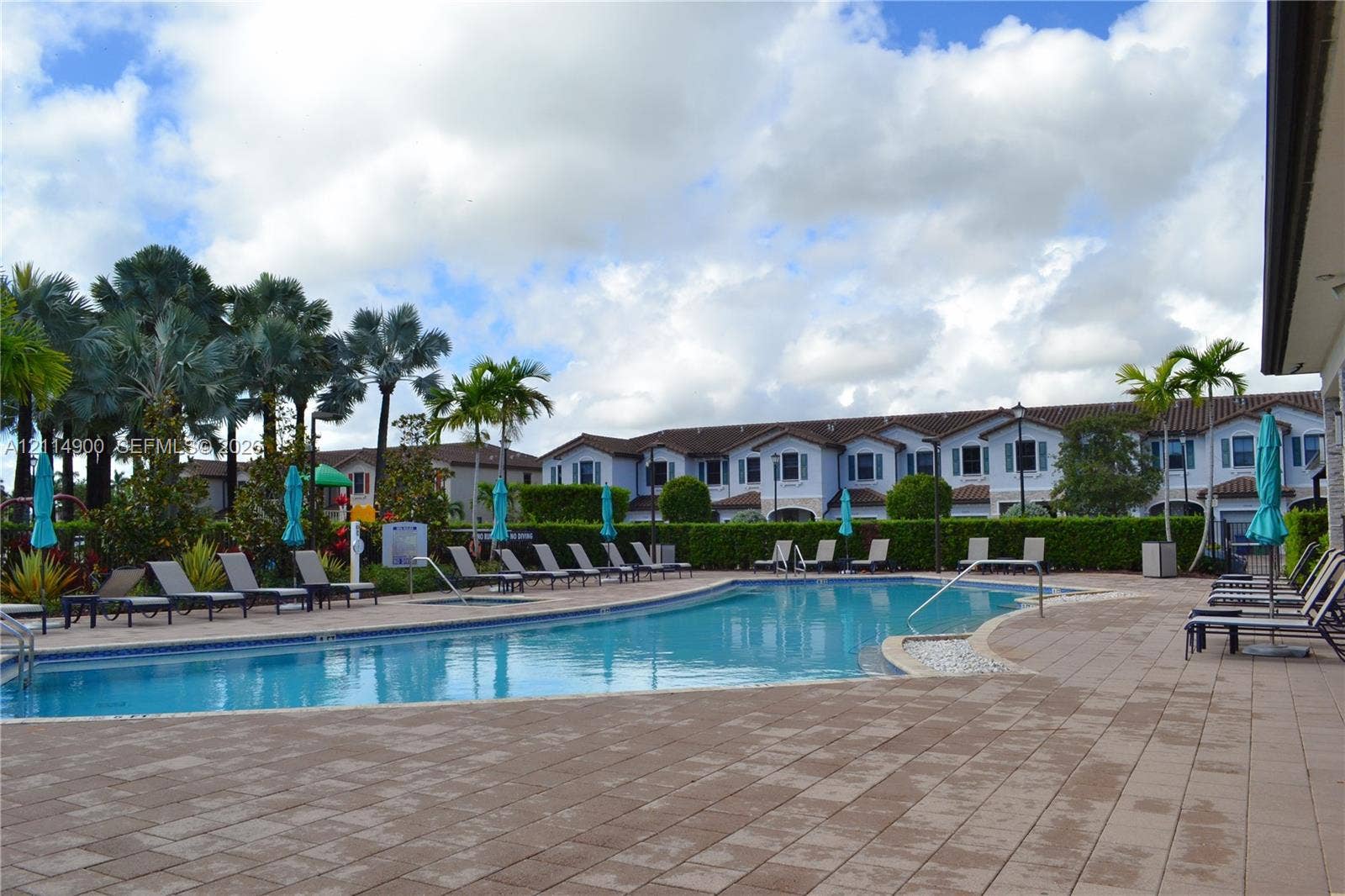 25048 SW 113th Place, Homestead, FL 33032 Swimming pool with a paved deck, perimeter landscaping, and metal handrails
