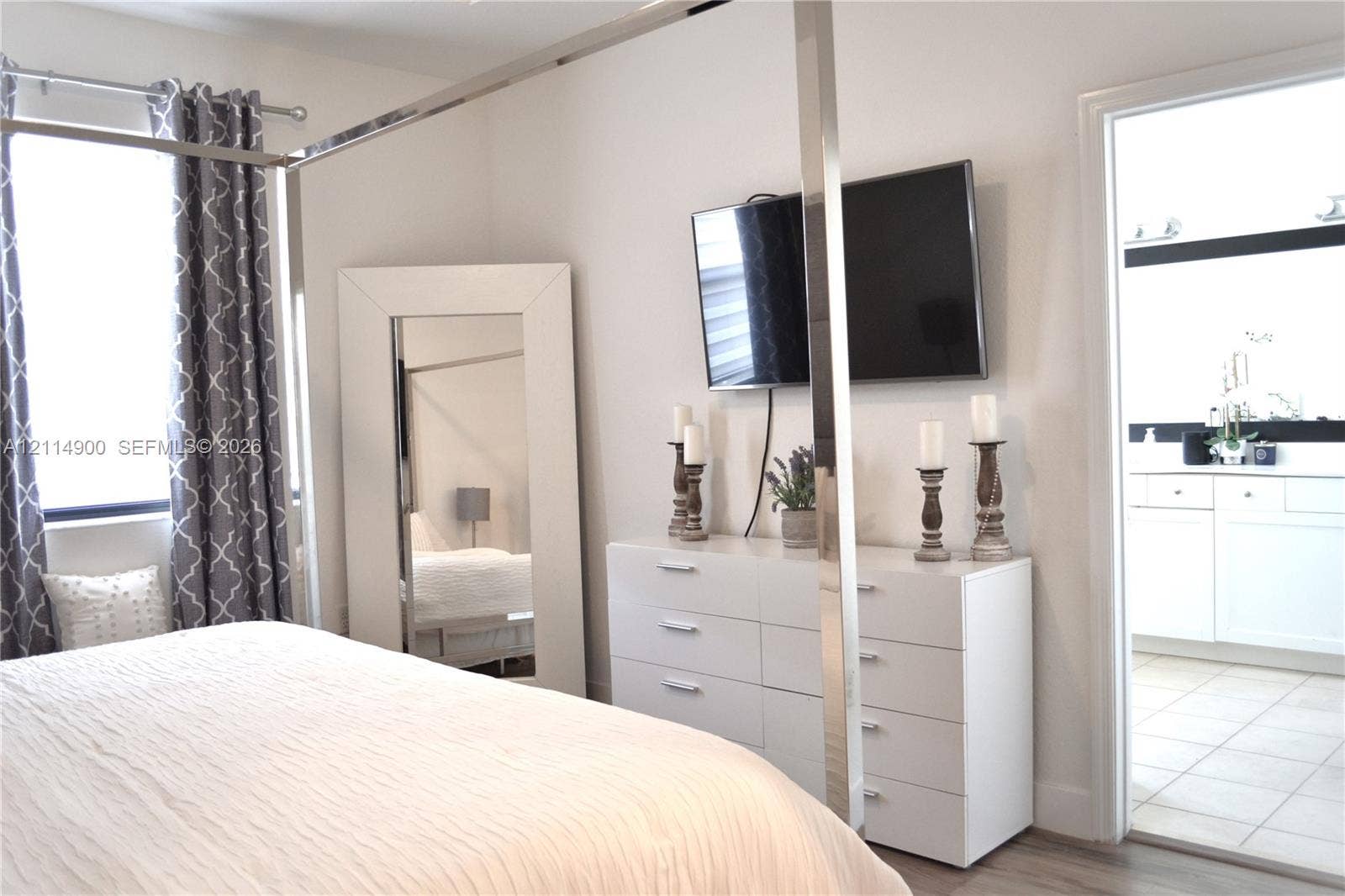 25048 SW 113th Place, Homestead, FL 33032 Neutral-toned room featuring light-colored wood-finish flooring, a metal-framed canopy structure, and an entryway with tile flooring