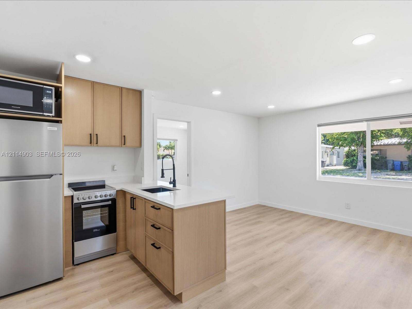 1129 NE 16th Avenue, #1, Fort Lauderdale, Fort Lauderdale, FL 33304 Kitchen featuring light-tone cabinetry, quartz countertops, stainless steel appliances, a matte black faucet, and wood-finish flooring