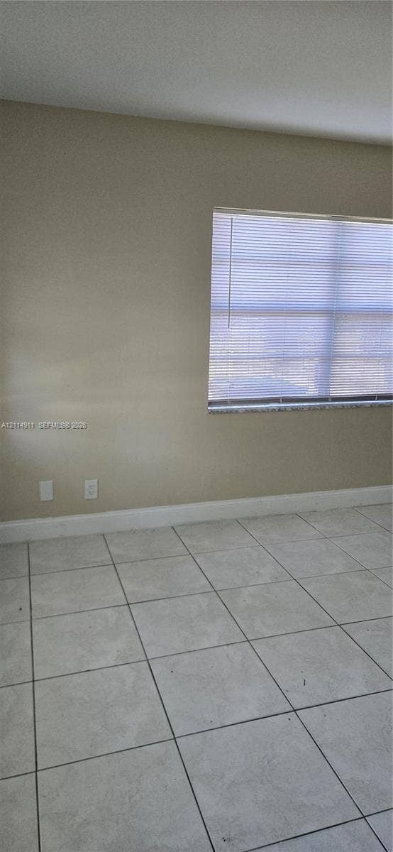 1045 Miami Boulevard, #A, Delray Beach, Delray Beach, FL 33483 Neutral-toned interior walls featuring large-format ceramic tile flooring and a window with integrated blinds