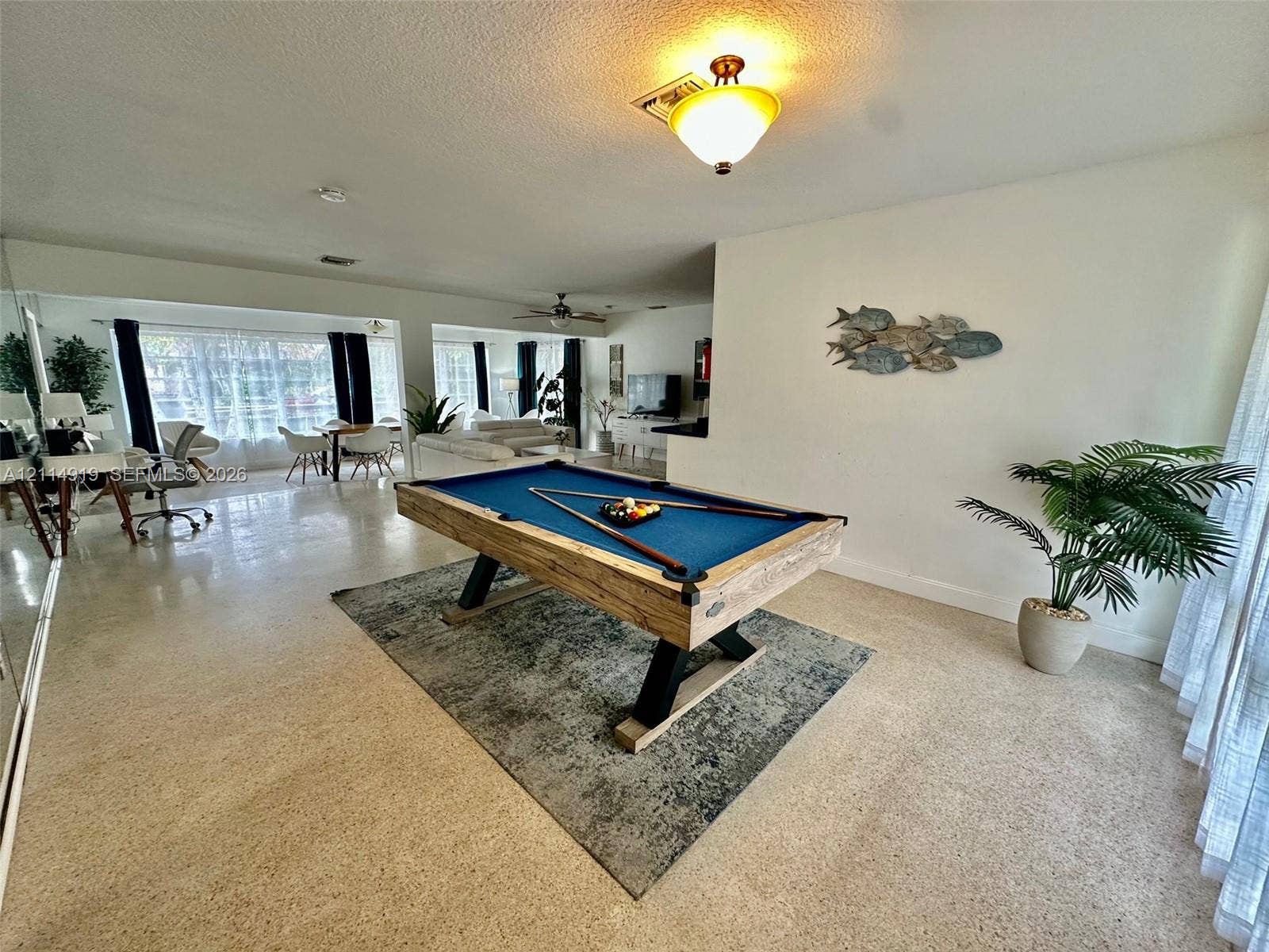 2901 NW 9th Terrace, #., Wilton Manors, Wilton Manors, FL 33311 Open-concept interior featuring light-toned terrazzo flooring, expansive floor-to-ceiling windows, and a warm-toned flush-mount ceiling light fixture