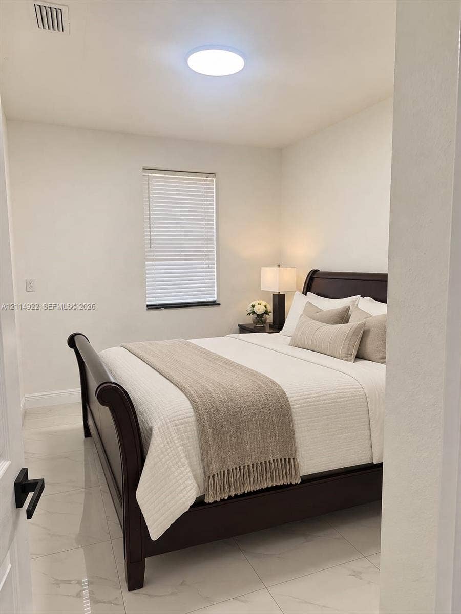 16201 SW 169th Avenue, #C, Miami, Miami, FL 33187 Interior room featuring polished tile flooring, neutral wall tones, a single window with horizontal blinds, and a circular flush-mount ceiling light fixture
