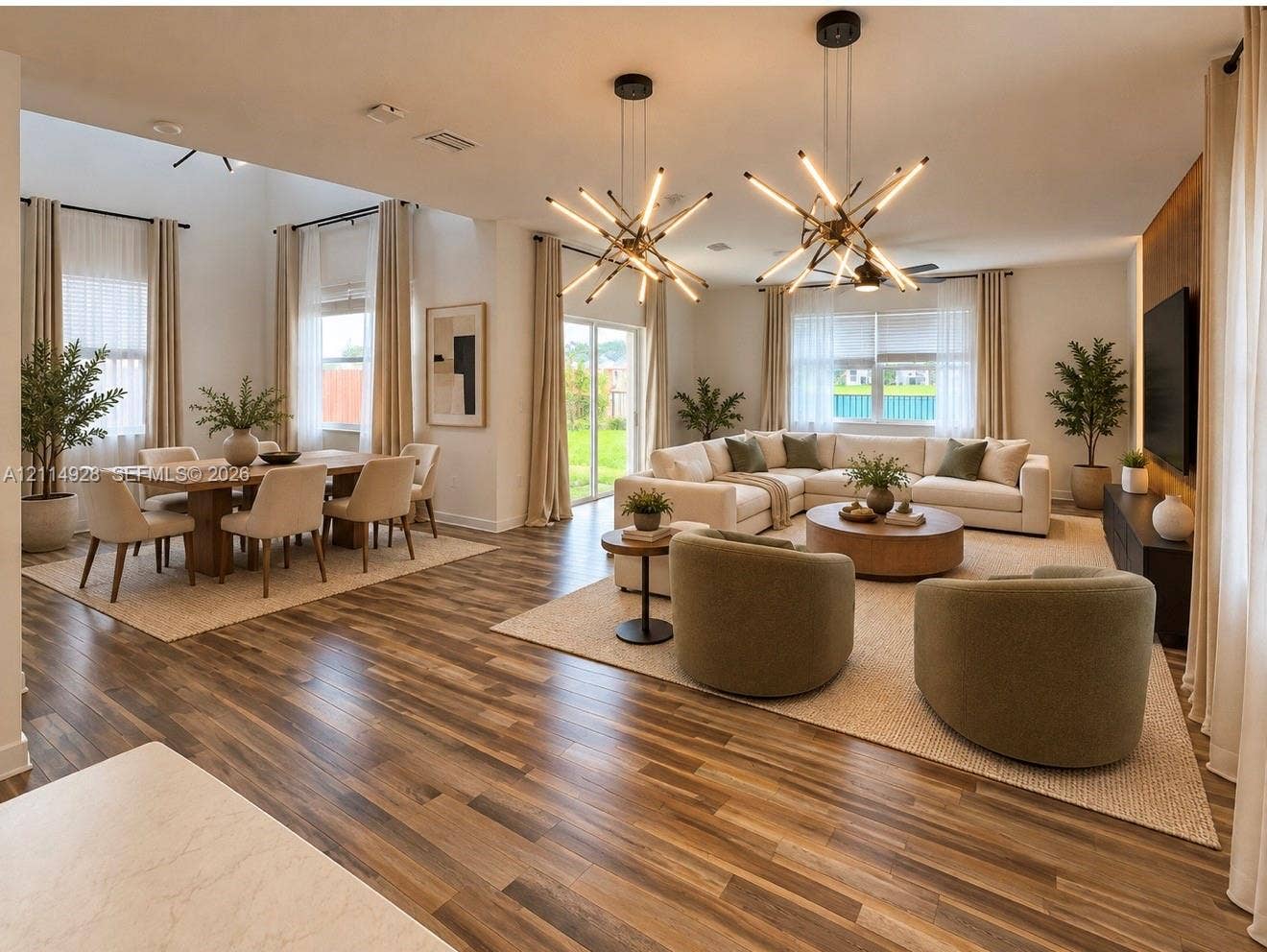 1411 SE 26th Road, Homestead, FL 33035 Open-concept interior featuring wood-finish flooring, high ceilings, dual geometric multi-arm pendant lights, and a floor-to-ceiling wood-panel accent wall