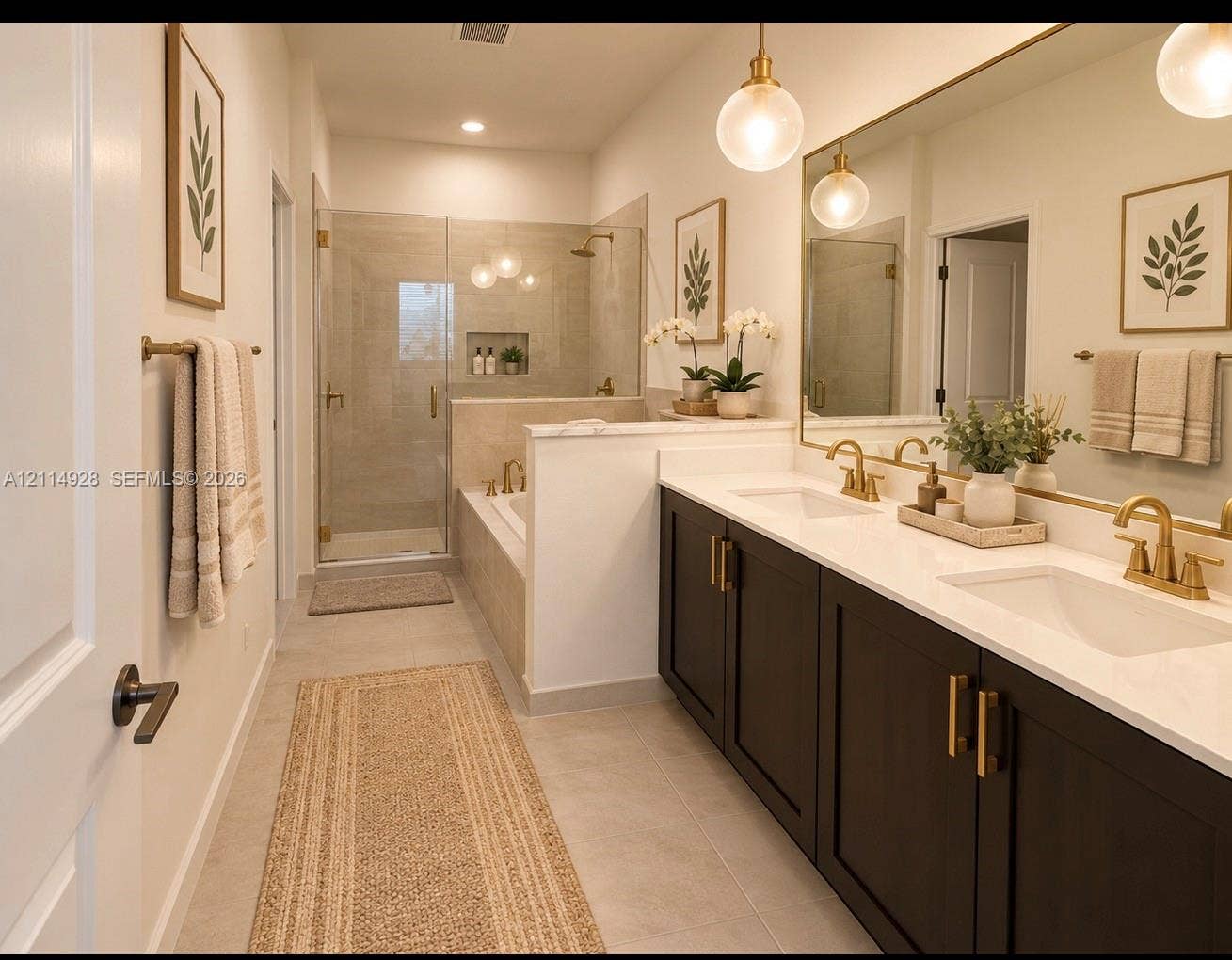 1411 SE 26th Road, Homestead, FL 33035 Double vanity featuring dark cabinetry, solid surface countertops, and gold-tone fixtures, complemented by a walk-in glass-enclosed shower, built-in soaking tub, and pendant lighting