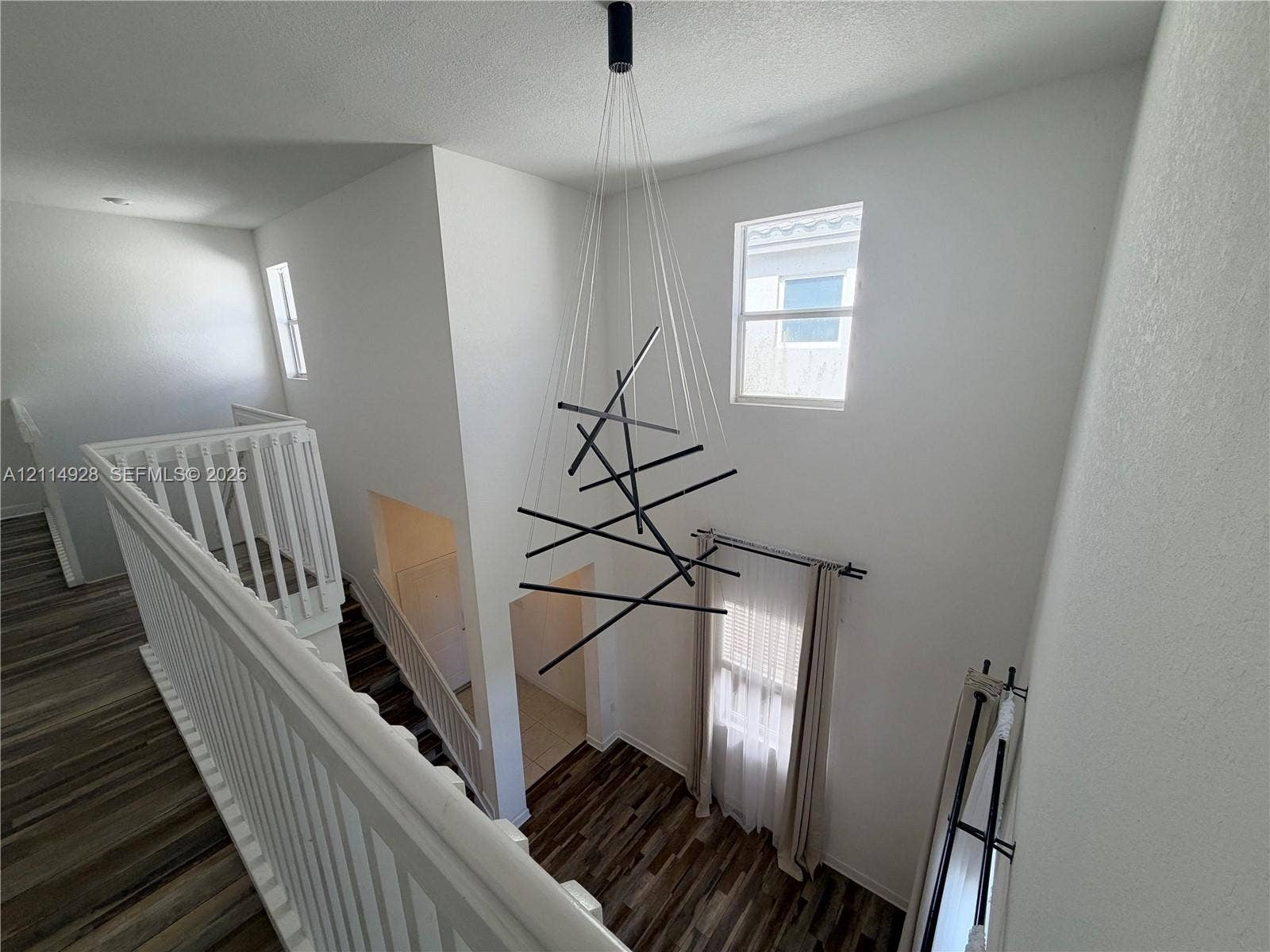 1411 SE 26th Road, Homestead, FL 33035 High-ceilinged entry featuring wood-finish flooring, a contemporary geometric chandelier, and white railings