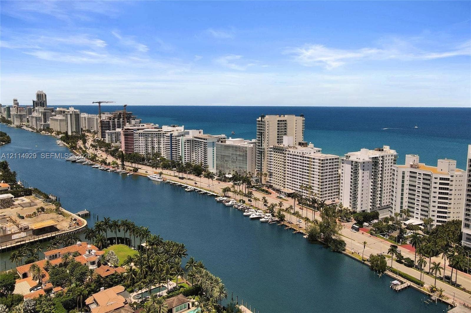 Aerial perspective featuring expansive waterway frontage, deep-water access for nautical vessels, palm-lined coastal topography, and a backdrop of the open ocean