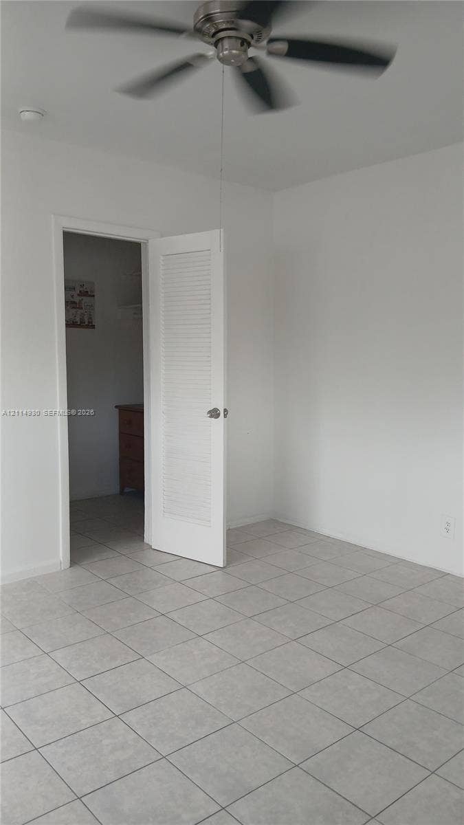 319 NE 2nd Street, #1, Hallandale Beach, Hallandale Beach, FL 33009 Neutral-toned tile flooring, ceiling fan with multi-blade design, and interior louvered door