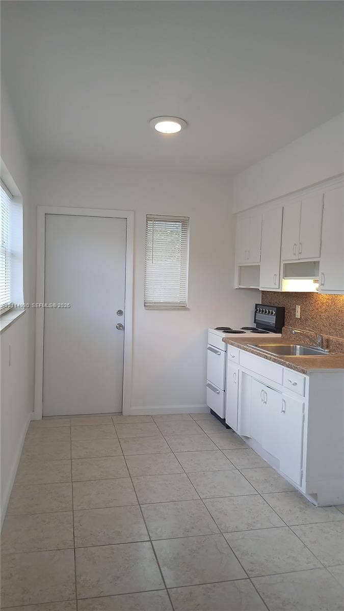 319 NE 2nd Street, #1, Hallandale Beach, Hallandale Beach, FL 33009 Kitchen featuring white cabinetry, stone-finish countertops, stainless steel sink, tile flooring, and recessed ceiling lighting