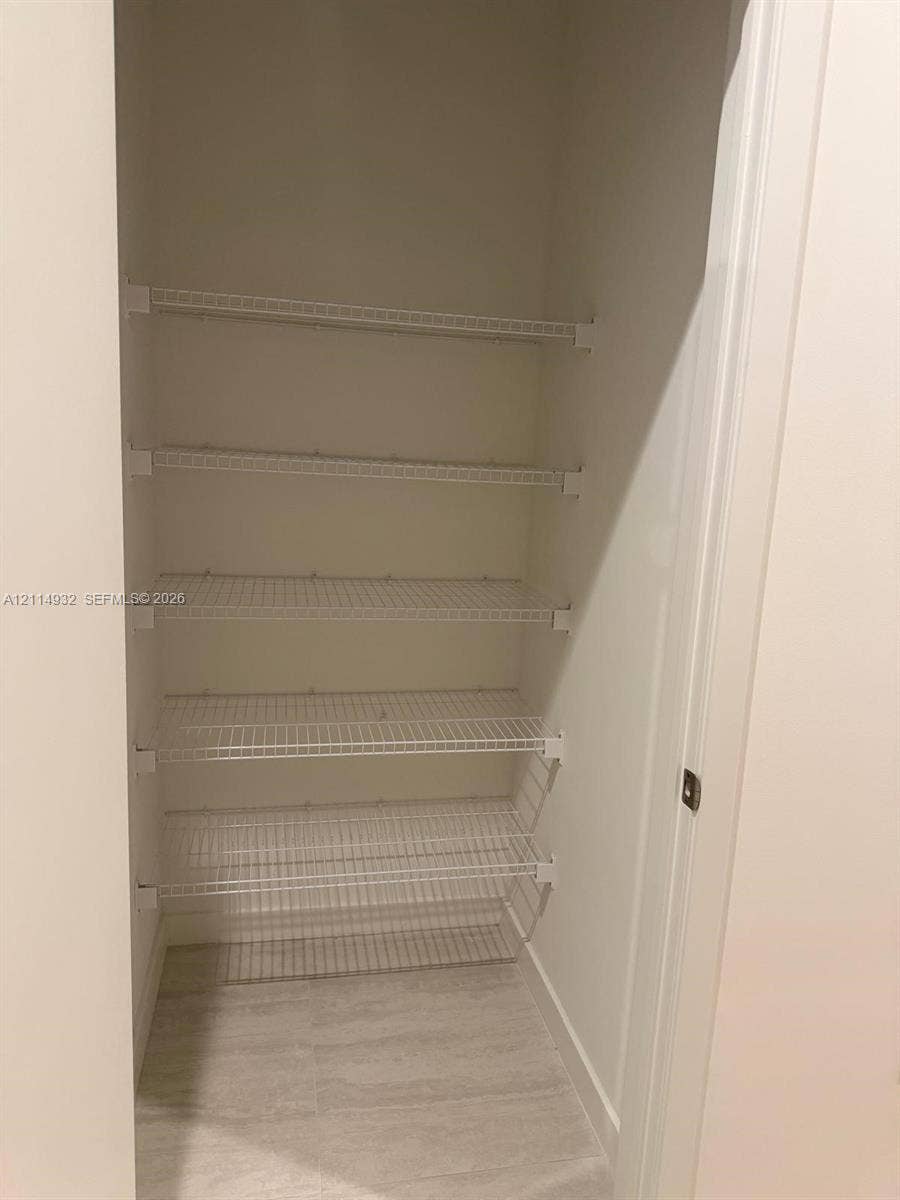 77 SE 5th Street, #607, Miami, FL 33141 Storage space featuring five tiers of white wire shelving and tile flooring