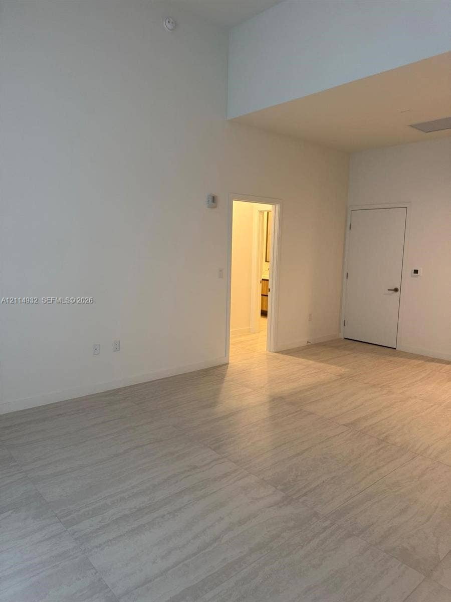 77 SE 5th Street, #607, Miami, FL 33141 High-ceiling interior featuring large-format tile flooring and neutral wall finishes
