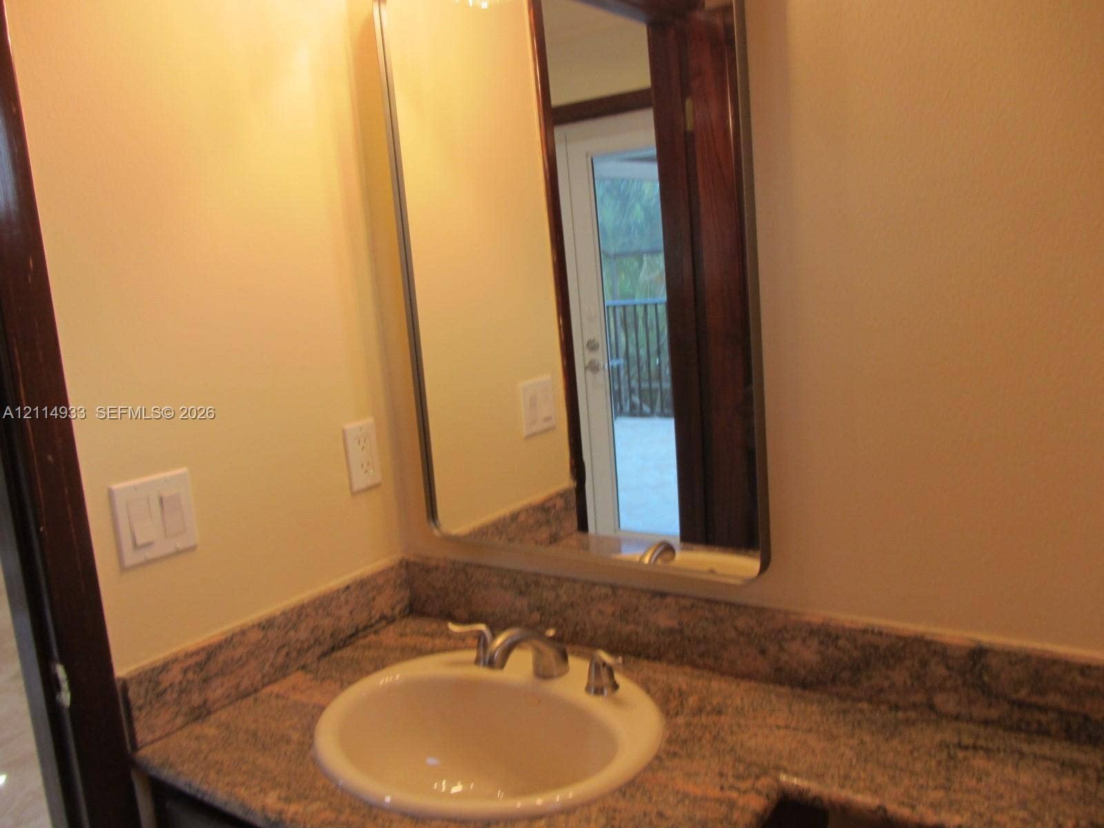 1001 Bella Vista Avenue, Coral Gables, Coral Gables, FL 33156 Upstairs bathroom Stone-finish countertop with an integrated basin, high-arch polished chrome faucet, and rectangular wall-mounted mirror
