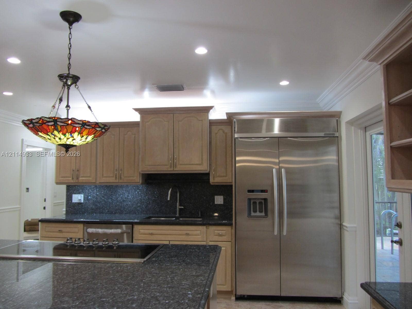 1001 Bella Vista Avenue, Coral Gables, Coral Gables, FL 33156 Kitchen featuring natural wood-finish cabinetry, dark stone countertops, recessed ceiling lighting, stainless steel side-by-side refrigerator, and a decorative stained glass pendant light