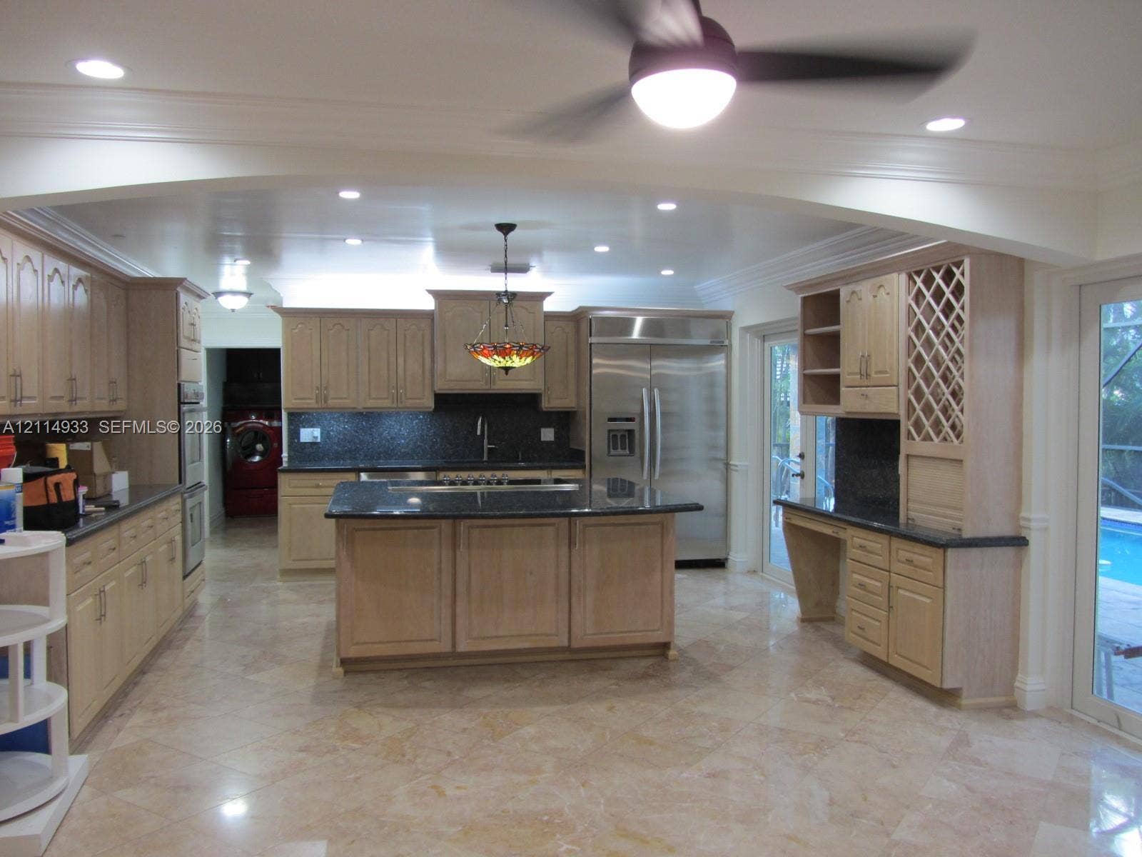 1001 Bella Vista Avenue, Coral Gables, Coral Gables, FL 33156 Kitchen featuring light wood cabinetry, center island, stone countertops, stainless steel appliances, and integrated wine rack