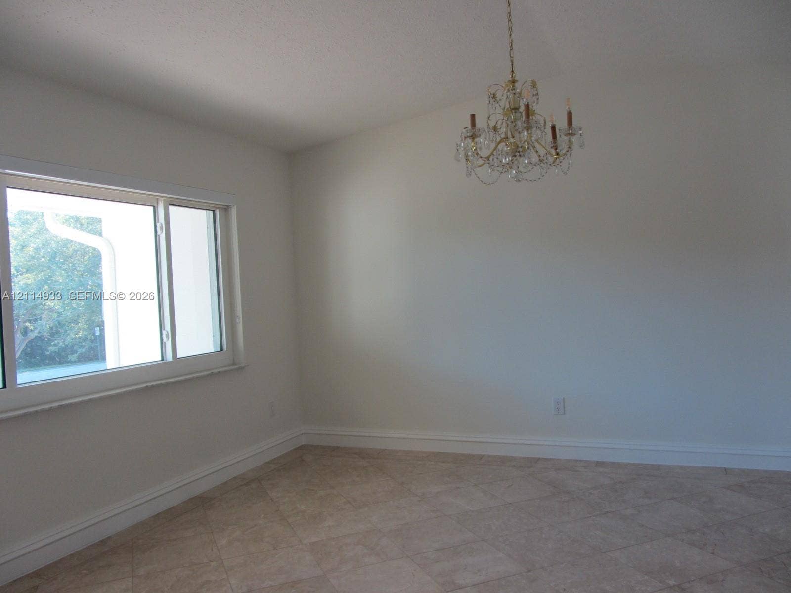 1001 Bella Vista Avenue, Coral Gables, Coral Gables, FL 33156 Vaulted ceiling, multi-light crystal chandelier, large-format tile flooring, and a wide horizontal window