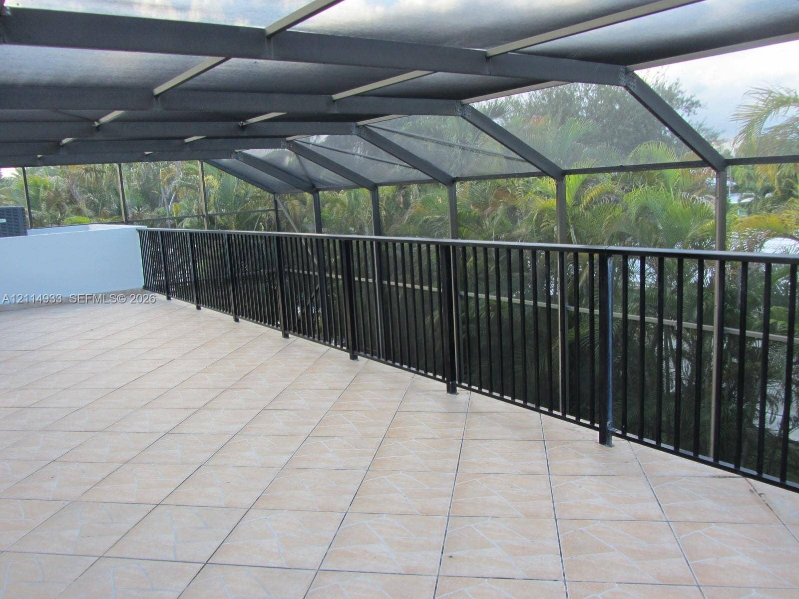 1001 Bella Vista Avenue, Coral Gables, Coral Gables, FL 33156 Screened-in balcony featuring tile flooring, metal structural framing, and a black vertical-slat railing