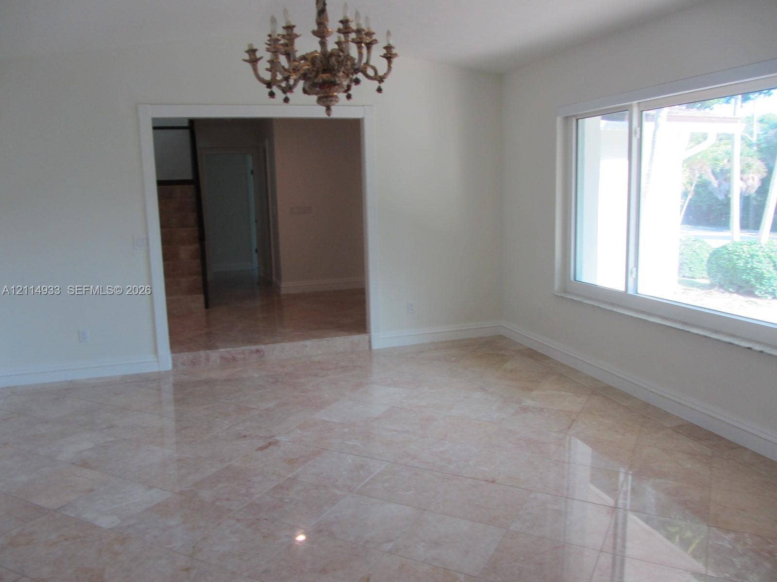 1001 Bella Vista Avenue, Coral Gables, Coral Gables, FL 33156 Polished stone tile flooring, ornate multi-arm chandelier, and expansive picture window