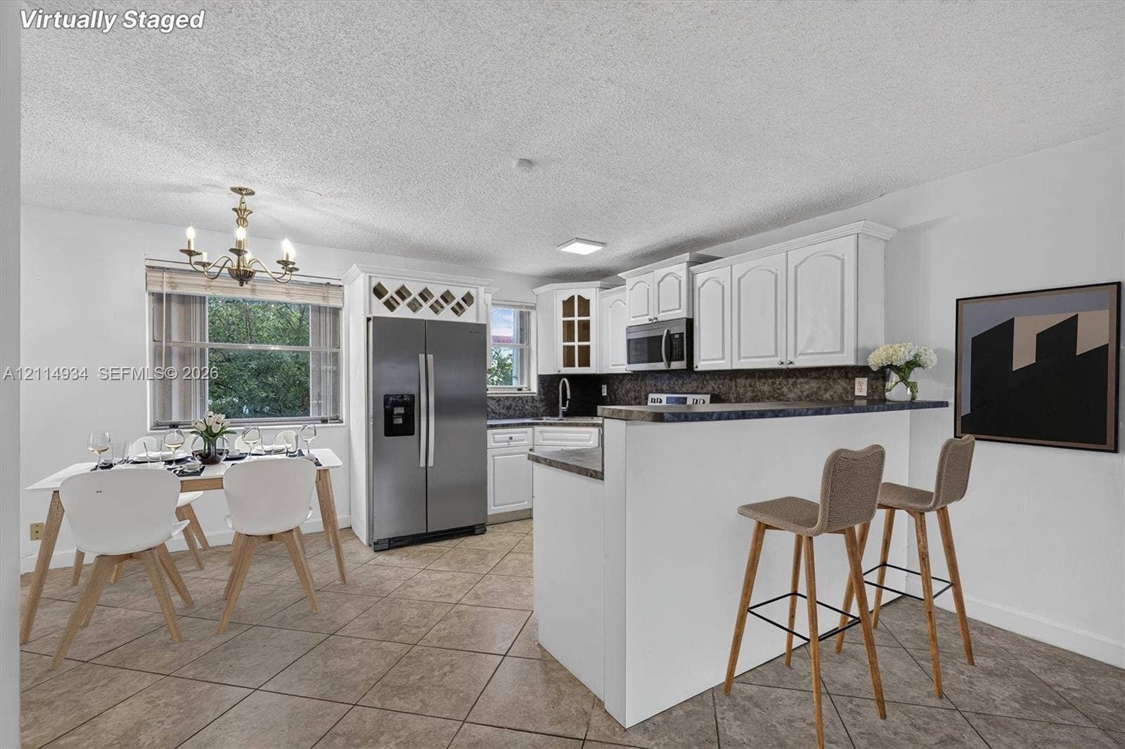 Kitchen featuring white cabinetry, stone-finish countertops, stainless steel appliances, built-in wine storage, and ceramic tile flooring