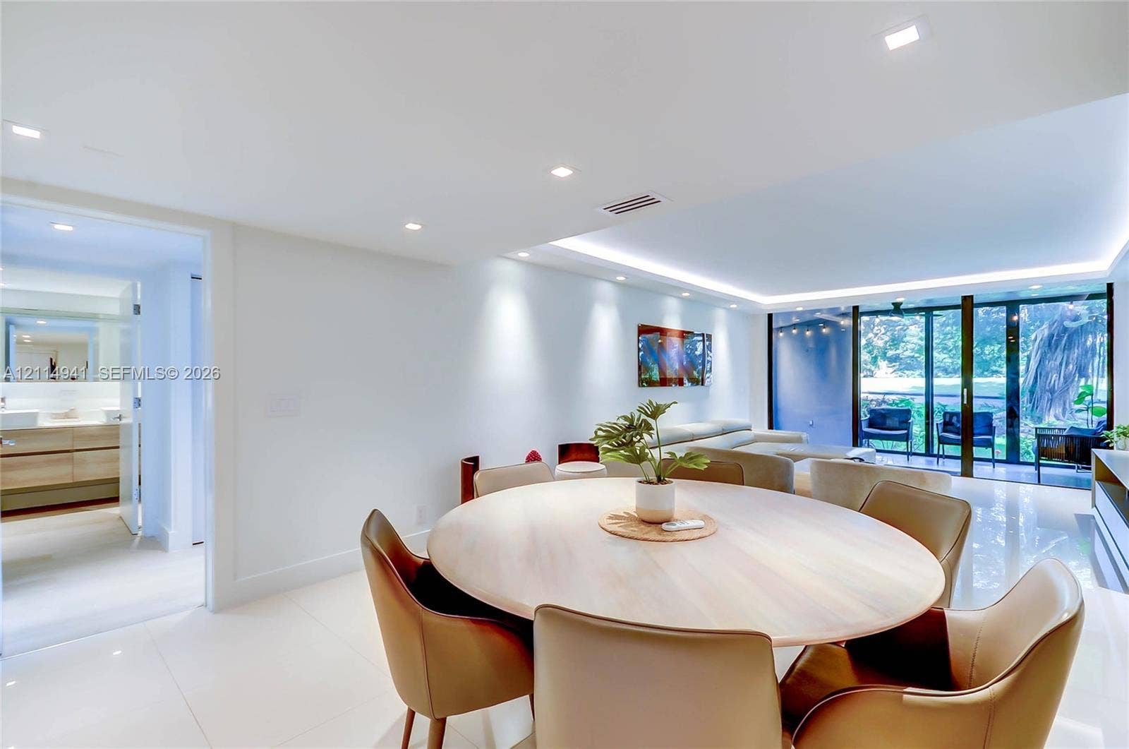 16175 Golf Club Road, #113, Weston, FL 33326 Open-concept interior featuring large-format tile flooring, recessed ceiling lighting, indirect cove lighting, and floor-to-ceiling sliding glass doors