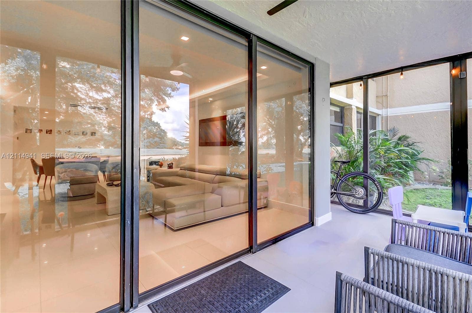 16175 Golf Club Road, #113, Weston, FL 33326 Enclosed patio with full-height black-frame glass sliders, recessed ceiling lighting, and tile flooring