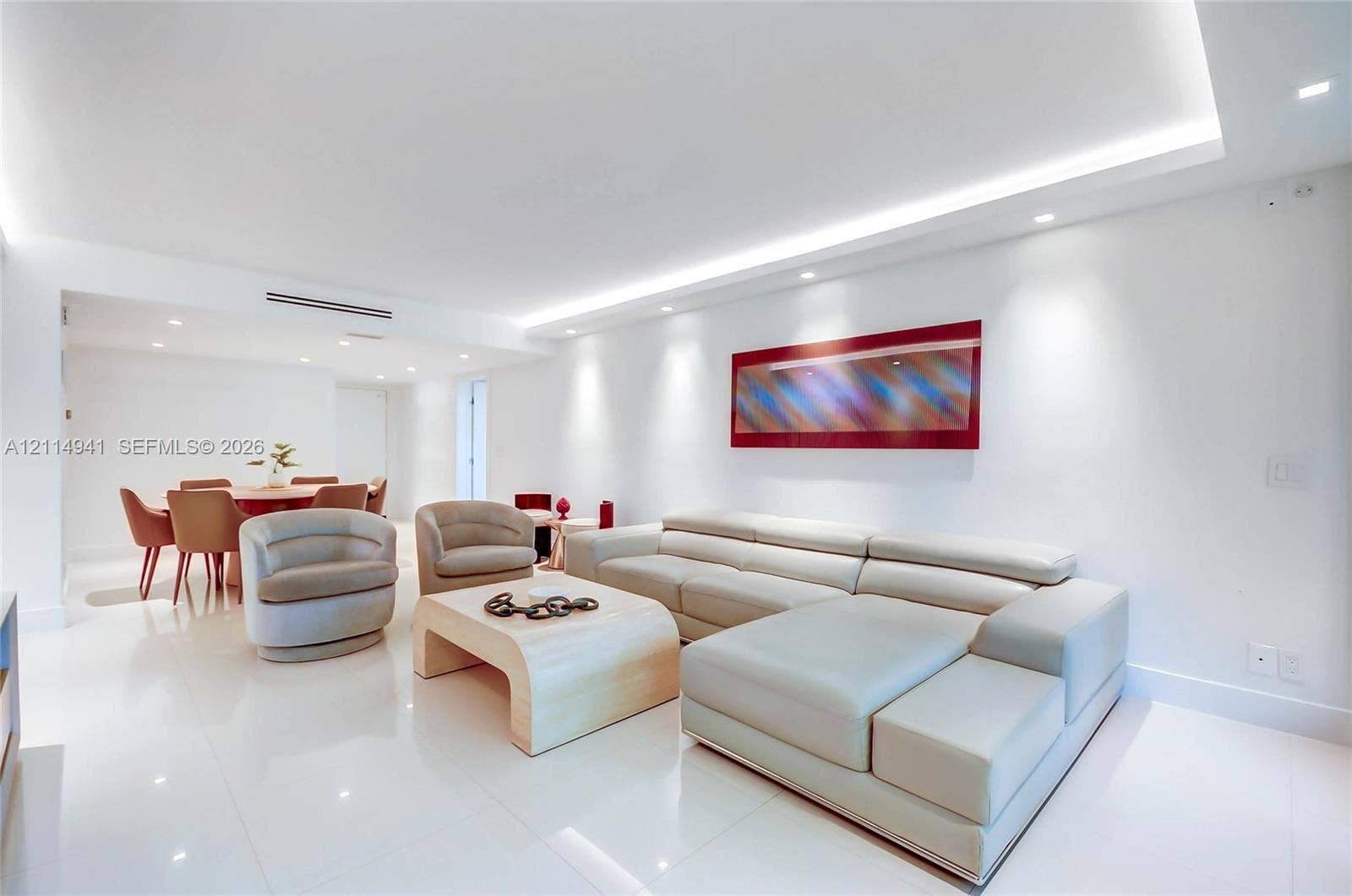 16175 Golf Club Road, #113, Weston, FL 33326 Open-concept living space featuring high-gloss tile flooring, recessed lighting, cove ceiling detail with integrated ambient lighting, and neutral wall finishes