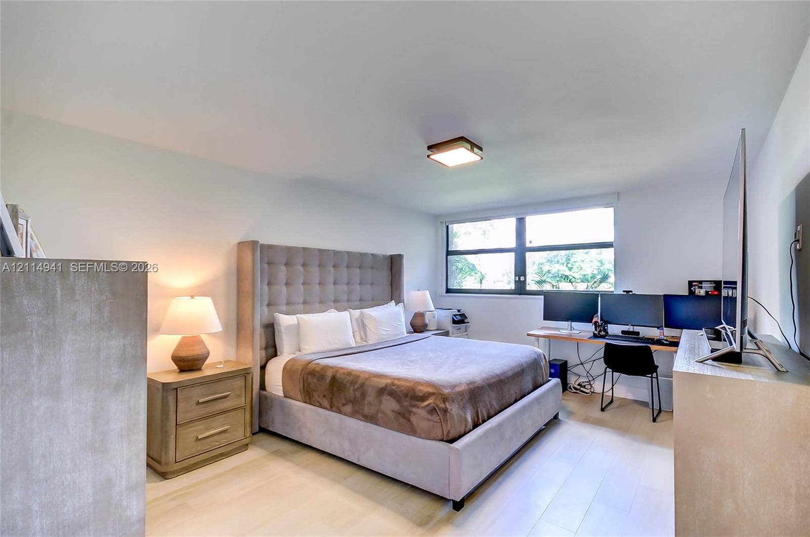 16175 Golf Club Road, #113, Weston, FL 33326 Light-filled room featuring neutral wall finishes, wood-finish flooring, and a flush-mount ceiling light